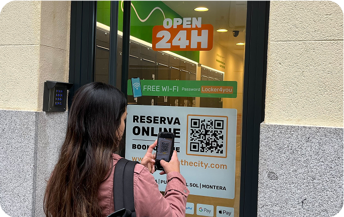 Photo du local de consigne de Gran Vía, Madrid avec une personne scannant le code QR pour effectuer la réservation
