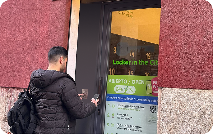 Foto del local de consignas de La Latina, Madrid con un usuario introduciendo el código de acceso en la entrada
