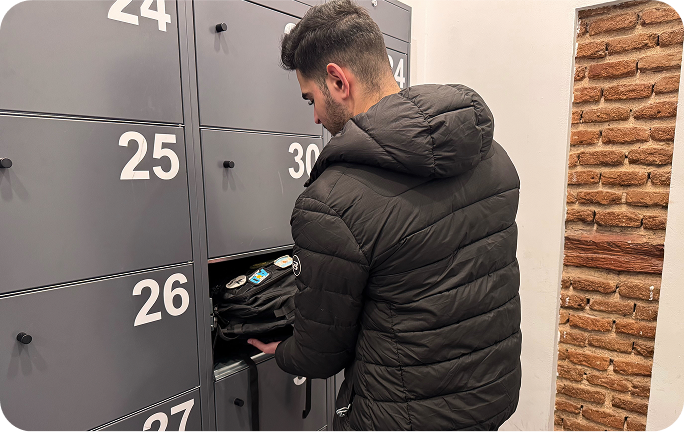 Foto del local de consignas de La Latina, Madrid con un usuario colocando sus maletas en la taquilla