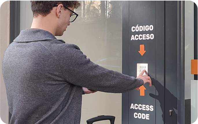 Foto del local de consignas de La Viña, Cádiz con un usuario introduciendo el código de acceso en la entrada