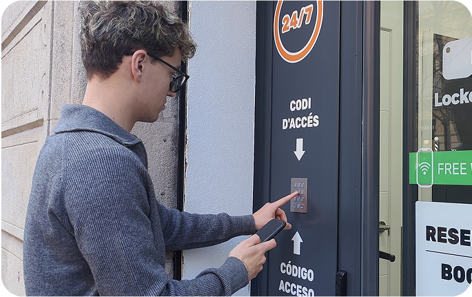 Foto del local de consignas de Ciutat Vella, Barcelona con un usuario introduciendo el código de acceso en la entrada