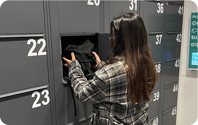 Photo of the storage facility at Plaza Mayor, Madrid with a user placing luggage in the locker
