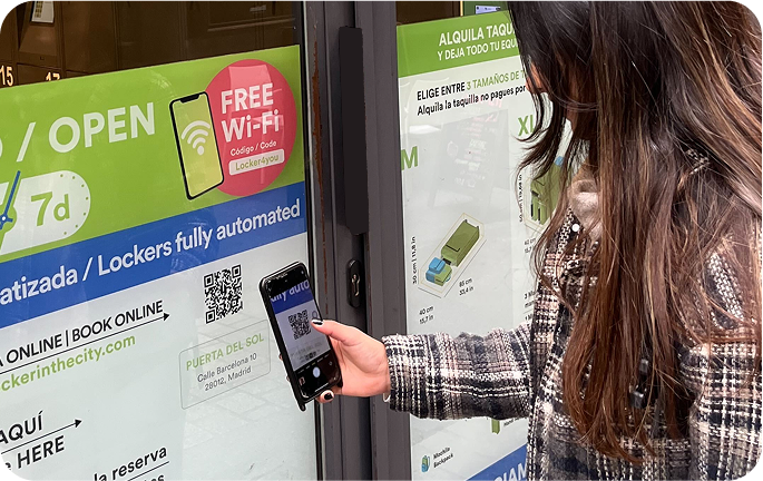 Photo du local de consigne de Puerta del Sol, Madrid avec une personne scannant le code QR pour effectuer la réservation