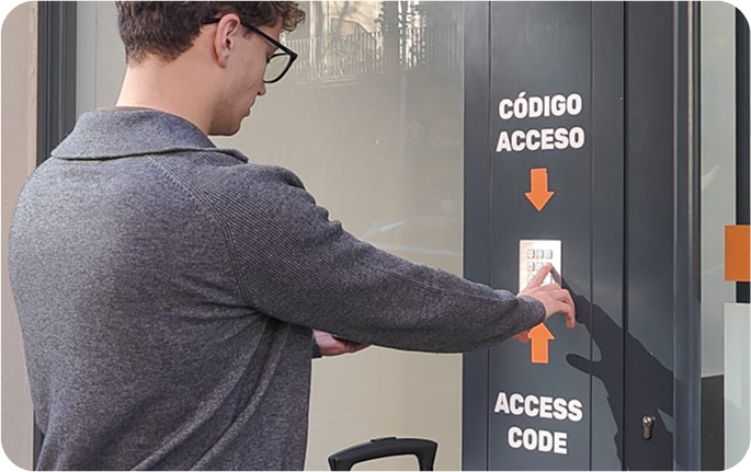 Foto del local de consignas de Universitat, Barcelona con un usuario introduciendo el código de acceso en la entrada